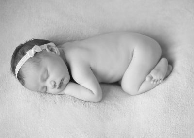 black and white newborn baby image sleeping with white headband