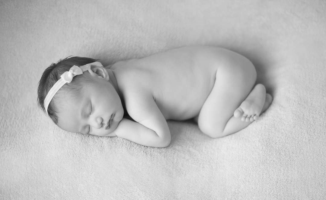 black and white newborn baby image sleeping with white headband