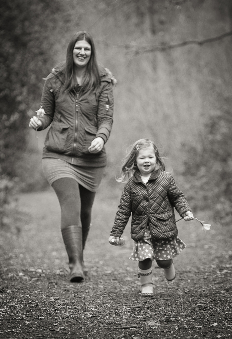 little girl running from mum during family photography session in norfolk