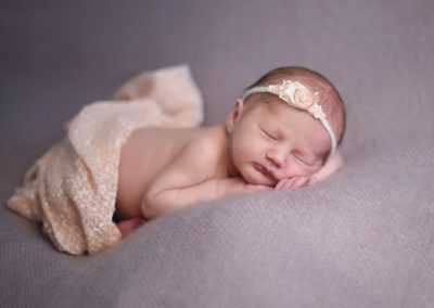baby sleeping in headband during newborn session in norfolk