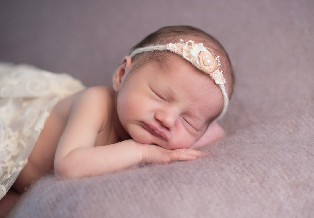 baby sleeping in headband during newborn session in norfolk
