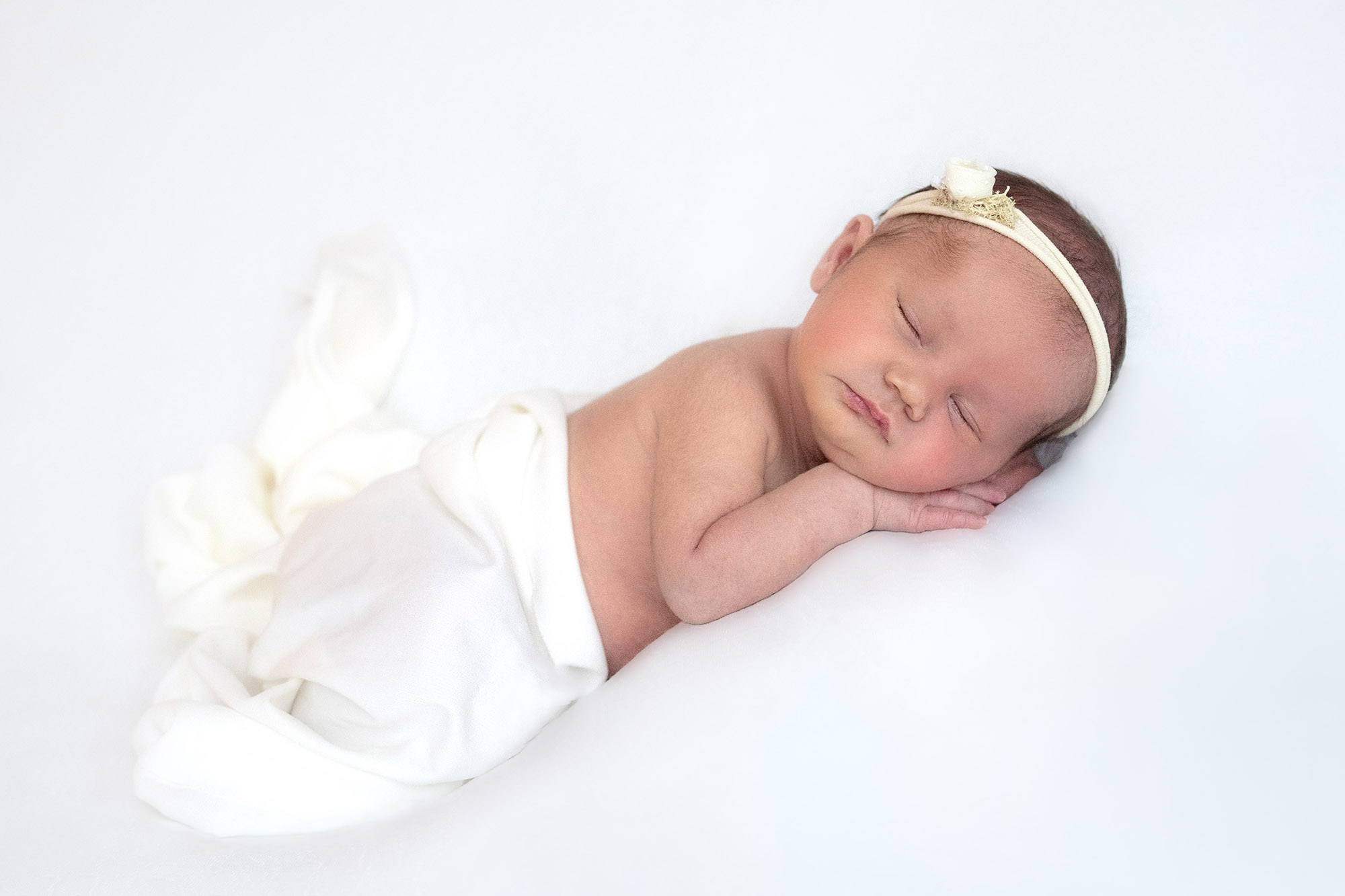 baby in white headband in natural newborn norfolk family photography session