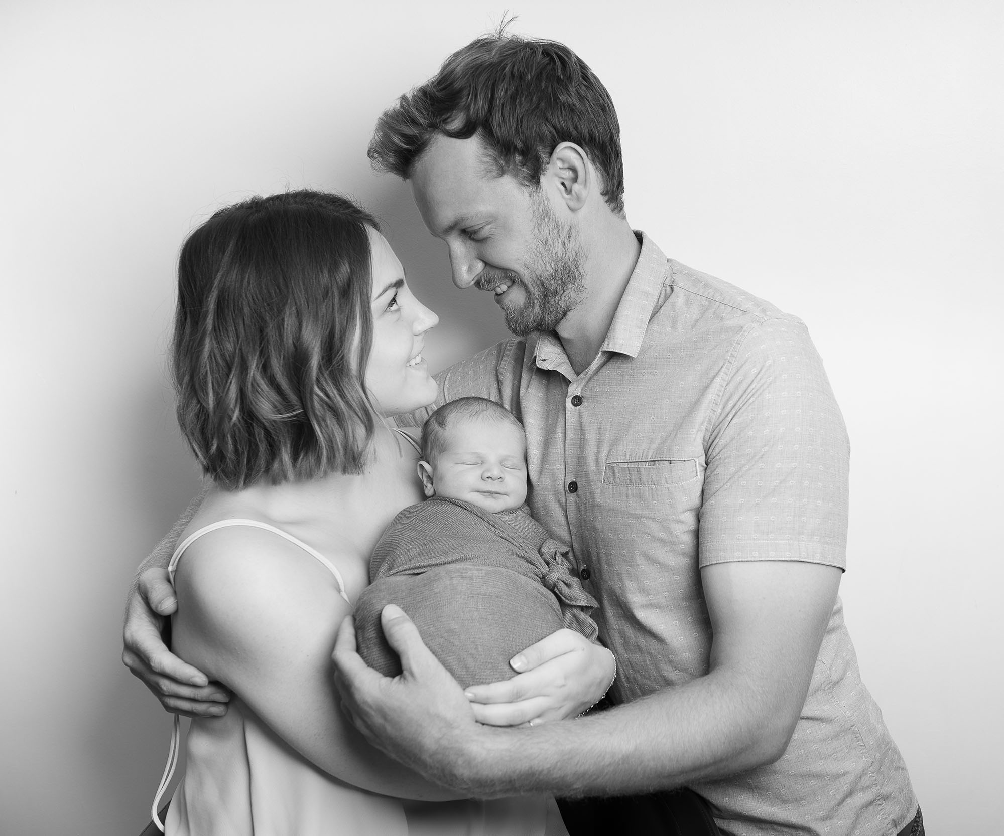 Happy family holding newborn during norwich newborn photography session with Alison Armstrong